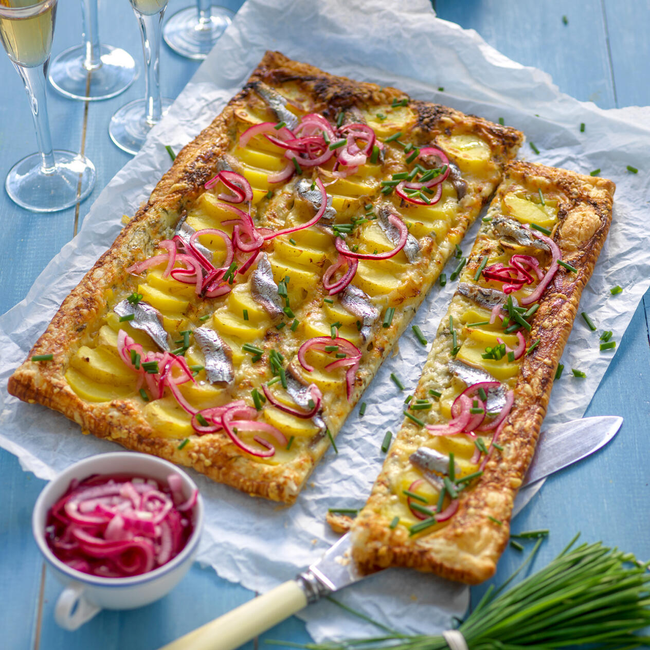 Smördegsflarn toppat med potatis, picklad lök och ansjovis