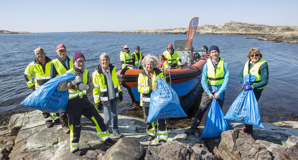 Strandstädargänget på Rockholmen efter dagens arbete. Fr v på berget: Arne Svensson, Bertil Widén, Barbro Knutsson, Monica Bodin, Lilian Althén, Lukas van der Heiden, Eva Widén. Fr v i båten: Ingela Stinasdotter, Stefan van der Heiden, Lisbeth Gustavsson, Rikard Kohlström. Foto: Anders Kristensson